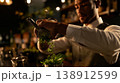 Bartender expertly muddling fresh herbs in a dimly lit cocktail bar 138912599