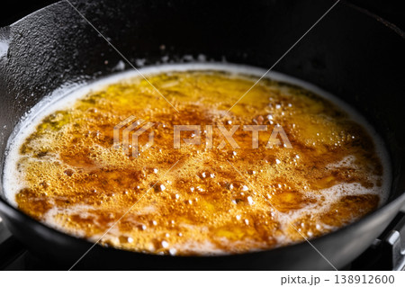 Butter melting in a cast iron skillet creates a golden, sizzling delight 138912600