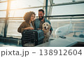 Couple smiling with their golden retriever at the airport during sunset 138912604