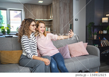Two Women Sitting on a Couch Taking a Selfie Two Women Sitting on a Couch Taking a Selfie 138912823