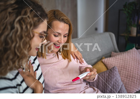 Two female friends are excited about the results of a pregnancy test 138912825