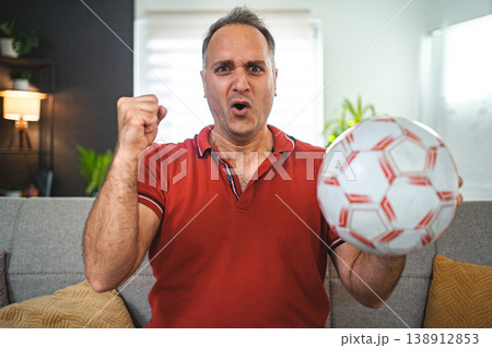 Worried middle aged man watching soccer game at home 138912853