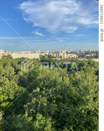 Panoramic cityscape with lush green park and residential buildings under blue sky, urban natural landscape Panoramic cityscape with lush green park and residential buildings under blue sky, urban natural landscape 138912892