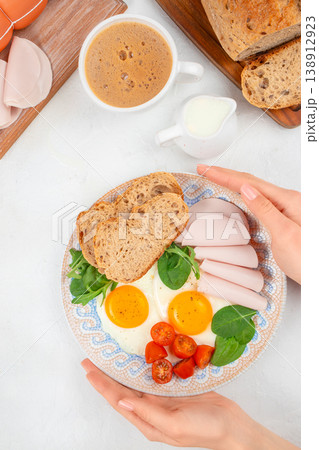 Breakfast plate with fried eggs, bread and turkey slices, top view morning meal with coffee Breakfast plate with fried eggs, bread and turkey slices, top view morning meal with coffee 138912923