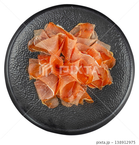 Jamon slices on black plate isolated on white background, top view cured meat appetizer Jamon slices on black plate isolated on white background, top view cured meat appetizer 138912975
