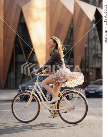 Woman enjoying city cycling feeling freedom and movement Woman enjoying city cycling feeling freedom and movement 138913615