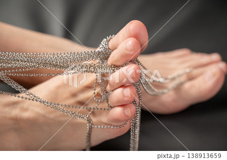 Foot fetish. Close-ups of naked female feet with silver chain jewelry. Foot fetish. Close-ups of naked female feet with silver chain jewelry. 138913659