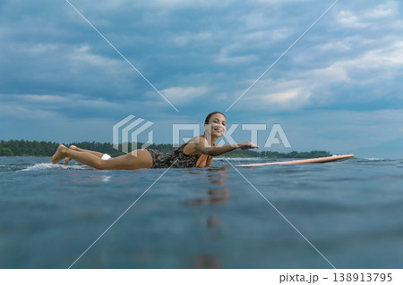 Determined Young Woman Confidently Paddling At Peaceful Seaside 138913795