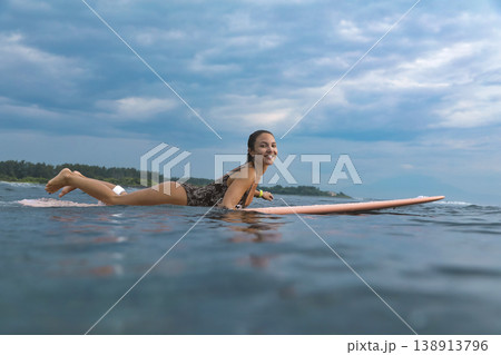 Determined Young Woman Confidently Paddling At Peaceful Seaside 138913796