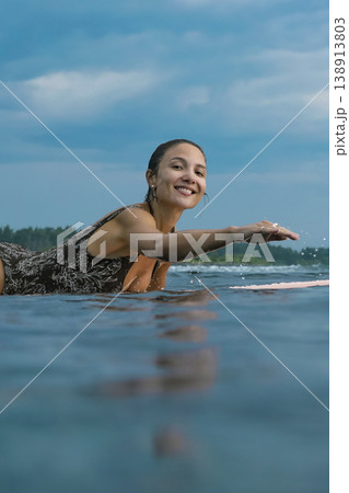 Energetic Woman With Bright Smile Engaged In Coastal Surfing Adventure Energetic Woman With Bright Smile Engaged In Coastal Surfing Adventure 138913803