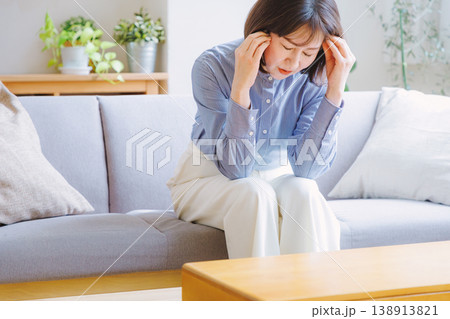 頭痛でこめかみを押さえるミドル女性 138913821