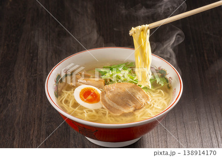 箸で麺を持ち上げると湯気が立ち上る味噌ラーメン。チャーシュー・煮卵・ネギが乗った本格的な一杯を捉えた 138914170