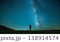 若い人物が夜の草原で明るい天の川を指差す 138914574