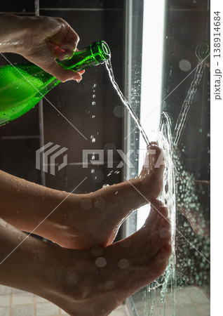 Foot fetish. A woman pours beer from a bottle onto her toes. 138914684