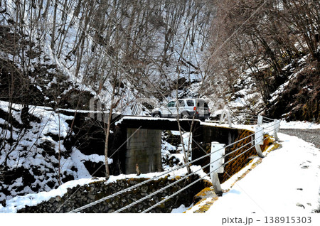 まだ雪が残ろ早春の林道大菩薩峠線を走るSUV 138915303