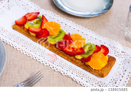 Puff pastry cake with custard, tangerine, kiwi and strawberry Puff pastry cake with custard, tangerine, kiwi and strawberry 138915885