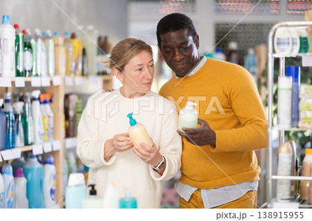 Before buying in household shop, African male customer with European wife choose liquid hand soap Before buying in household shop, African male customer with European wife choose liquid hand soap 138915955