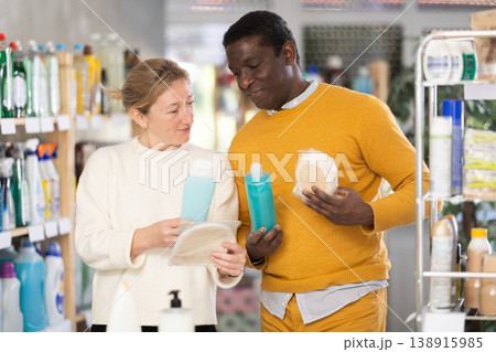 During shopping, African male client with wife advised and choose shampoo, shower gel, bast wisp 138915985