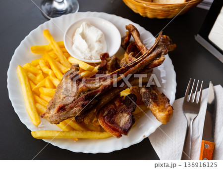 Grilled lamb ribs with french fries. Traditional spanish dish cordero ribs and patata Grilled lamb ribs with french fries. Traditional spanish dish cordero ribs and patata 138916125