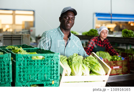 Portrait of an african american farmer with a crate of Peking cabbage 138916165