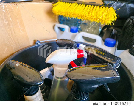 A close-up of spray bottles with cleaning products and a brush in a bucket. Cleaning and cleaning products. High quality photo 138916215