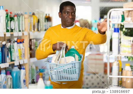 African American man with basket is full of goods, looking for something African American man with basket is full of goods, looking for something 138916697