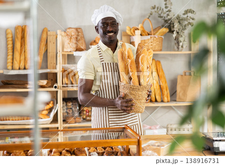 Portrait of joyful man baker with baguettes Portrait of joyful man baker with baguettes 138916731