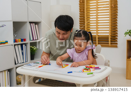 Caption/Description: father and child girl drawing and painting with colorful oil pastels on paper Caption/Description: father and child girl drawing and painting with colorful oil pastels on paper 138917415