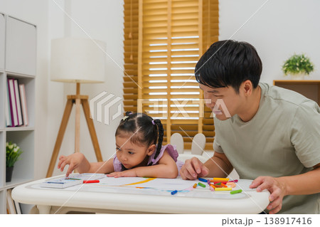 Caption/Description: father and child girl drawing and painting with colorful oil pastels on paper Caption/Description: father and child girl drawing and painting with colorful oil pastels on paper 138917416