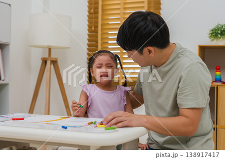 father comforting crying preschool child girl while drawing and painting with oil pastels at father comforting crying preschool child girl while drawing and painting with oil pastels at 138917417
