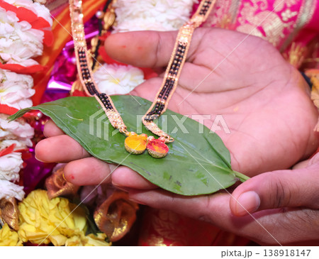 Mangalsutra is held in the hand in Indian wedding ceremony	 138918147