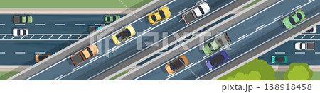 Top view of complex multi level highway interchange with heavy traffic flow. Cars and trucks of various colors move along several lanes seen from an aerial flat perspective with urban landscaping.  138918458