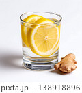 Fresh Lemon and Ginger Slices in a Clear Glass Filled with Water on a Clean Surface Fresh Lemon and Ginger Slices in a Clear Glass Filled with Water on a Clean Surface 138918896