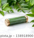 Elegant jade roller on a marble surface surrounded by lush green foliage and natural elements Elegant jade roller on a marble surface surrounded by lush green foliage and natural elements 138918900