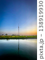A Tranquil Reflection of a Communication Tower at Sunset, Bathing the Scene in Orange and Blue 138919930