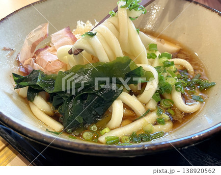 冷たいぶっかけうどん ─ 箸でうどんを持ち上げたアップ・わかめ 冷たいぶっかけうどん ─ 箸でうどんを持ち上げたアップ・わかめ 138920562