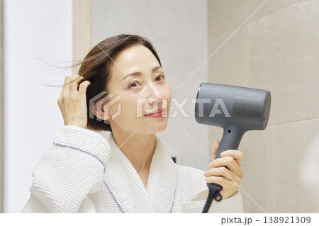 ドライヤーで髪を乾かす女性 138921309