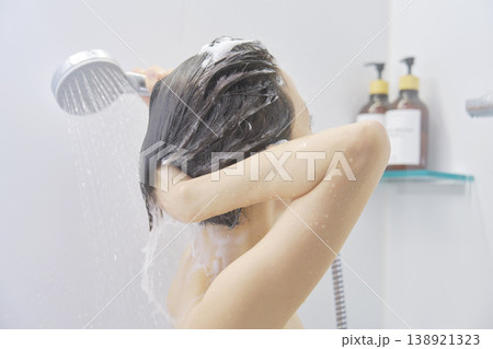 シャワーで髪を洗い流す女性 138921323