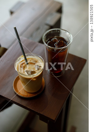 Cups of iced milk latte coffee and iced black coffee on table by the window. Cups of iced milk latte coffee and iced black coffee on table by the window. 138921505