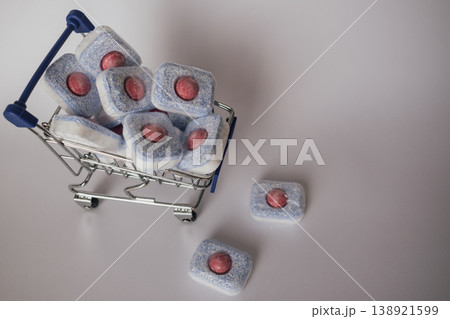 Organized laundry: stack of bright dishwasher tablets in a wire shopping trolley Organized laundry: stack of bright dishwasher tablets in a wire shopping trolley 138921599