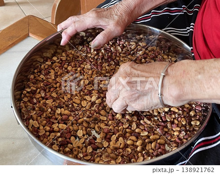 Close Up Of Hand Sorting Roasted Peanuts For Traditional Filling Preparation Close Up Of Hand Sorting Roasted Peanuts For Traditional Filling Preparation 138921762