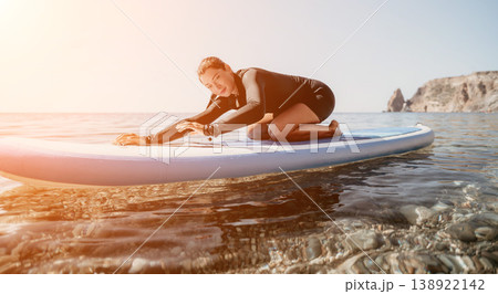 Woman sup yoga. Happy sporty woman practising yoga pilates on paddle sup surfboard. Female stretching doing workout on sea water. Modern individual female hipster outdoor summer sport activity. Woman sup yoga. Happy sporty woman practising yoga pilates on paddle sup surfboard. Female stretching doing workout on sea water. Modern individual female hipster outdoor summer sport activity. 138922142