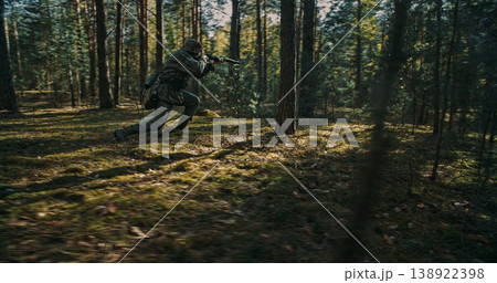 German soldier crouching and aiming rifle in forest during combat 138922398