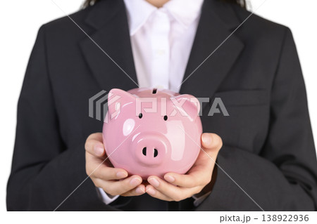 豚の貯金箱を持つスーツを着た女性 豚の貯金箱を持つスーツを着た女性 138922936