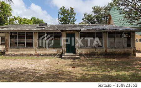 Weathered single-story school building with corrugated metal roof Weathered single-story school building with corrugated metal roof 138923552