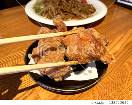 鶏の唐揚げ ─ 箸で持ち上げたクローズアップ 138923623