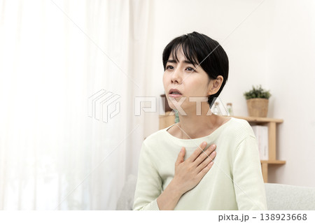 急な体調不良を感じて胸を押さえる女性　胸痛　ストレス 138923668