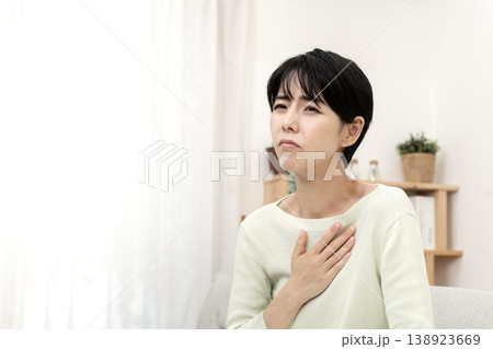 急な体調不良を感じて胸を押さえる女性　胸痛　ストレス 138923669
