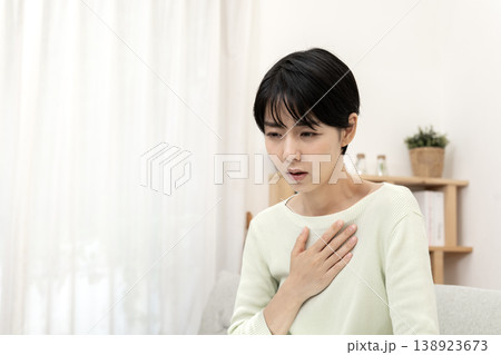 急な体調不良を感じて胸を押さえる女性　胸痛　ストレス 138923673