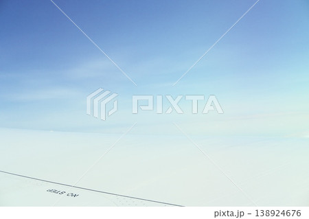 飛行機雲を背景にした、穏やかな青空と翼の先端 138924676